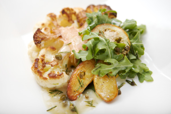 A Pan Seared Cauliflower with Steak caper and lemon sauce. With some rosemary and roasted-potatoes along with petite arugula and fried lemon slices.