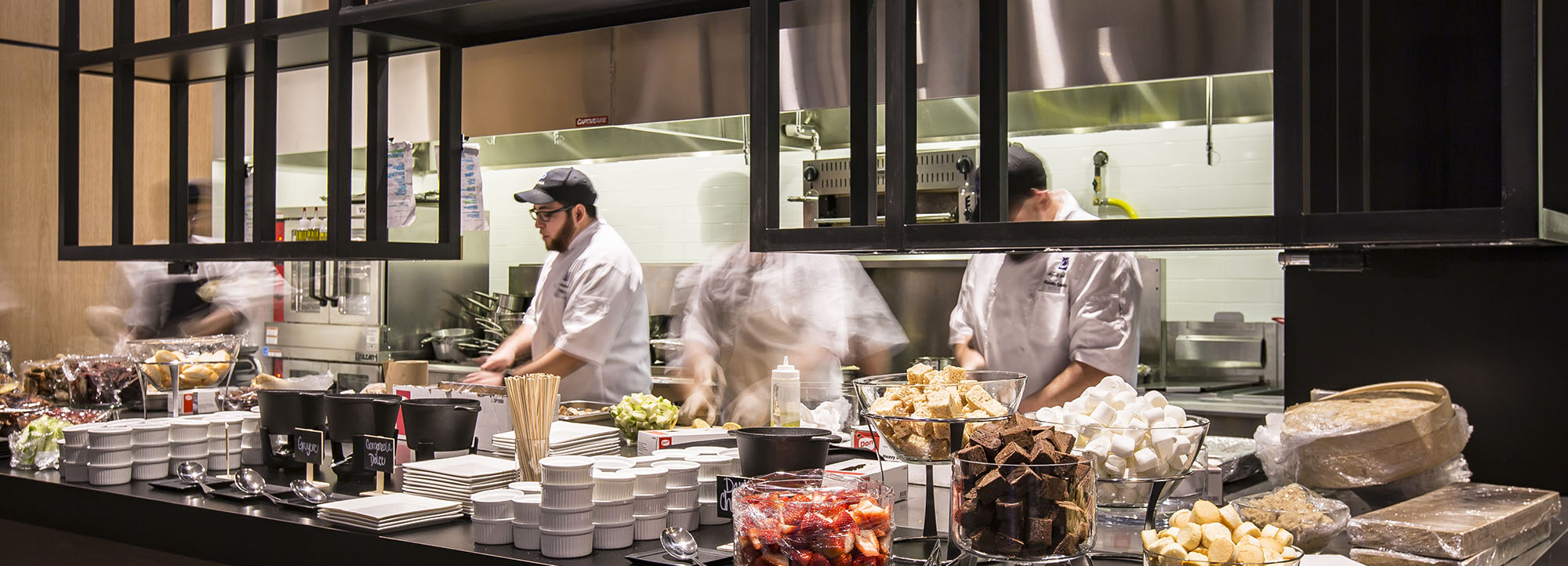 Chefs plating and preparing dishes in kitchen