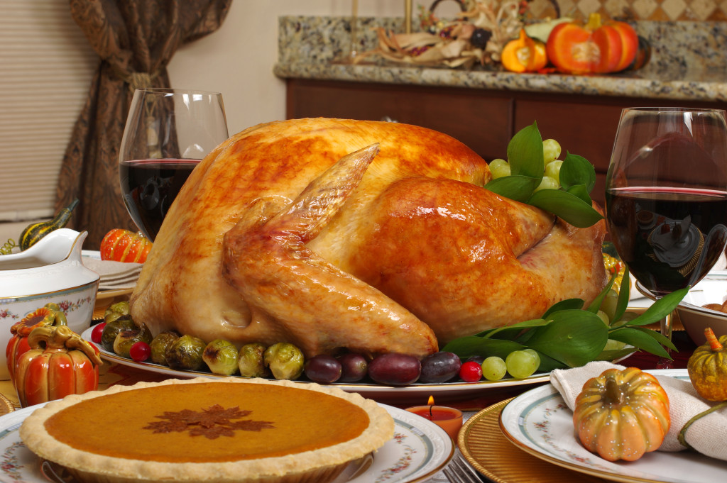 A turkey in the center surrounded by other Thanksgiving themed meals.