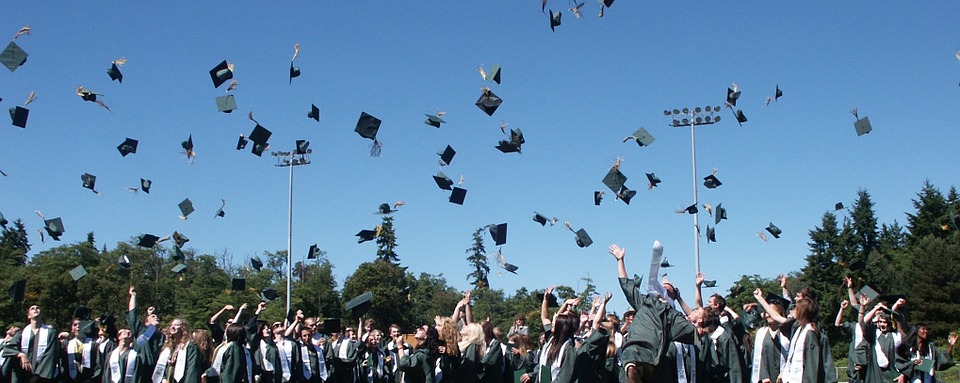Graduation caps being thrown in the air by students.