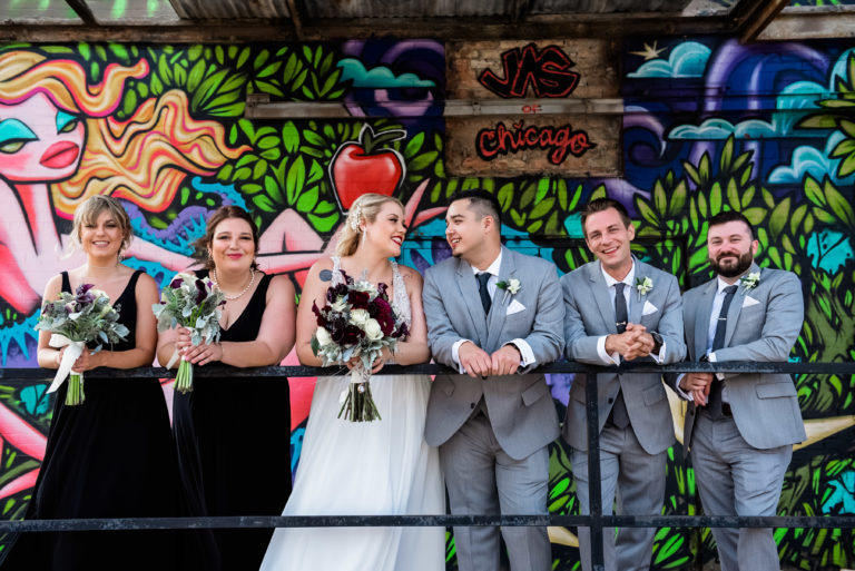 A wedding party posing in front of a colorful mural in Fulton Market