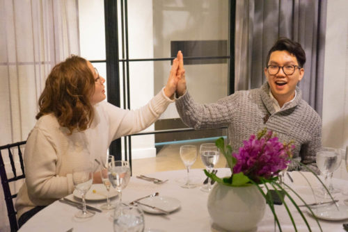 Happy couple high-fiving at tasting table